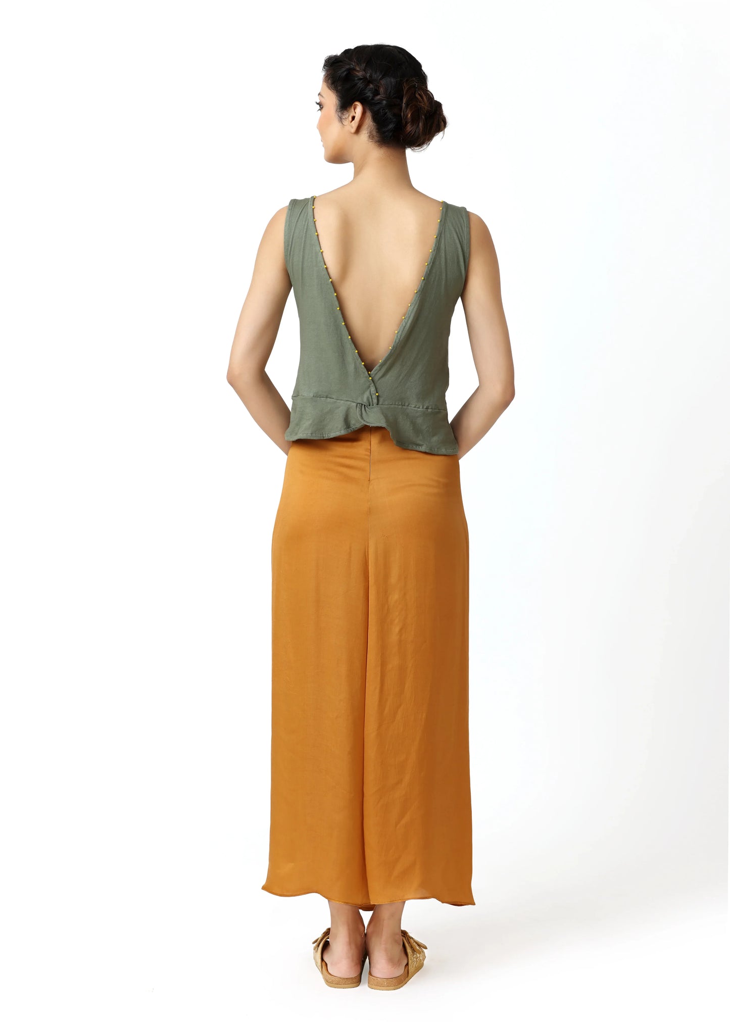 Sage green sleeveless top with deep V-back and bow detail, paired with mustard wide-leg pants, showcasing ALTER EGO’s. - Top DOVE - S - ALTER EGO