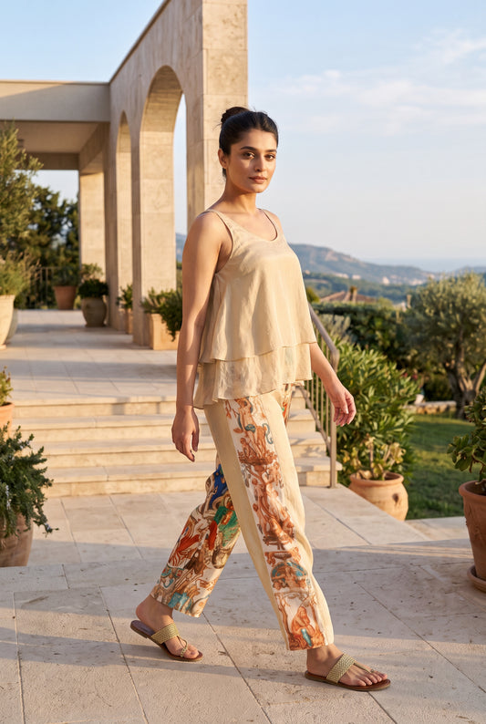 Wide-leg beige silk trousers with a colorful vintage-inspired print, worn with a flowing cream top and sandals. - Pantalon ZODIAQUE - S - ALTER EGO