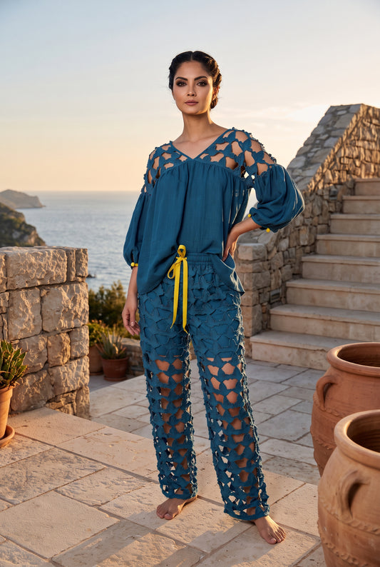 Woman wearing a flowing teal blue lace wide-leg pantsuit with openwork floral panels and yellow drawstring. - Pantalon DOVE - S / Bleu - ALTER EGO