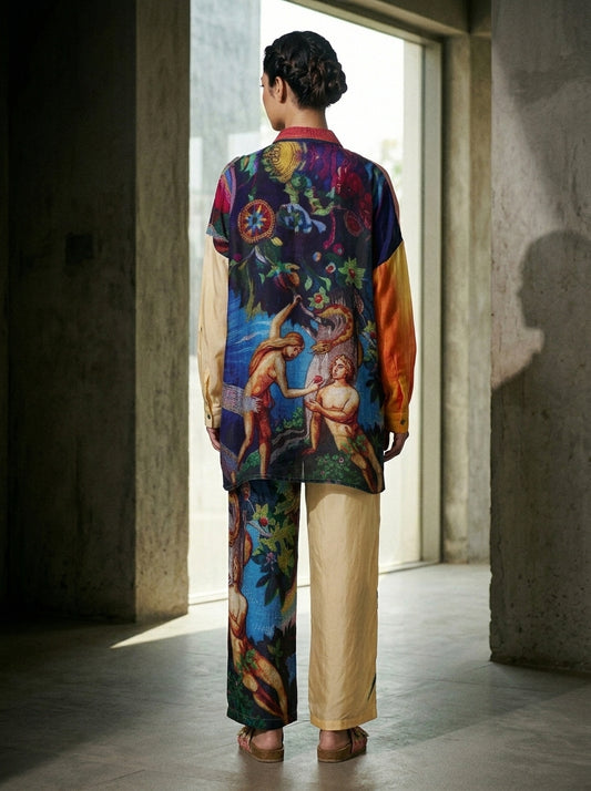 Woman modeling a long, multicolored blue blouse and matching trousers with ornate floral and mythic prints. - Chemise EDEN - XS - ALTER EGO